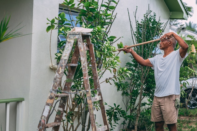 Un homme peignant une maison