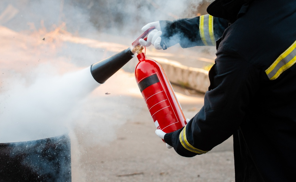 Homme éteignant un feu avec un extincteur