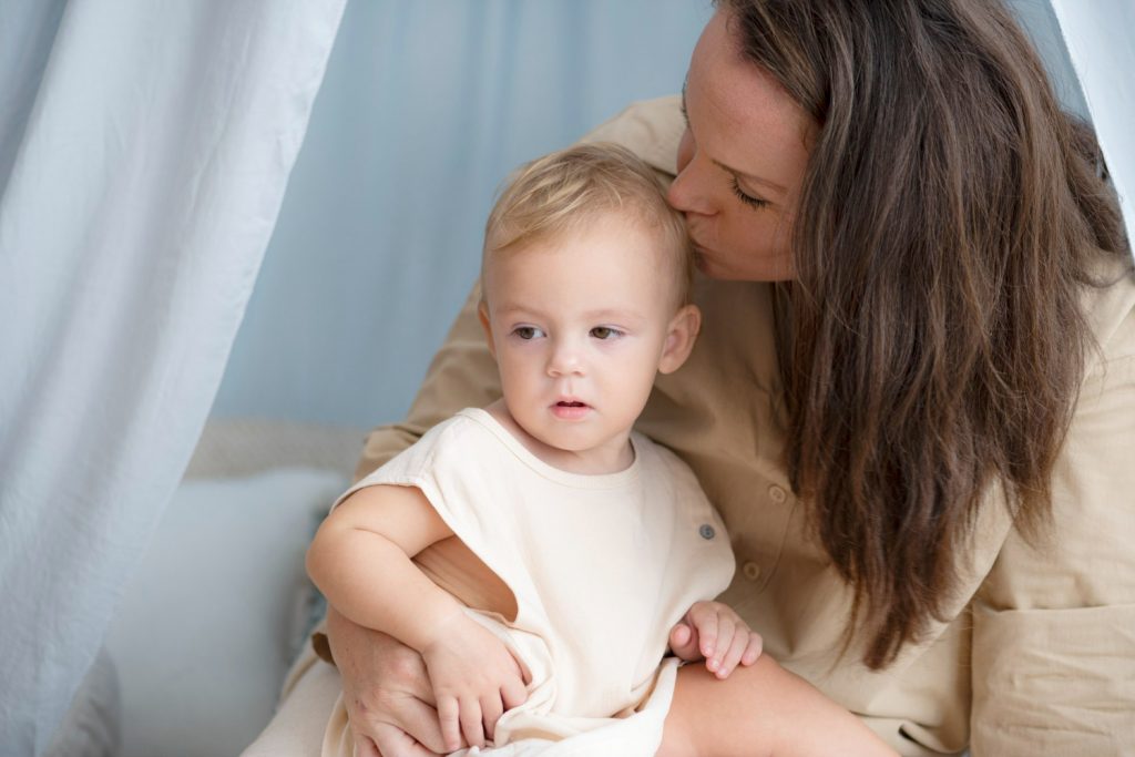 maman qui tient son fils en photo et lui embrasse la tete