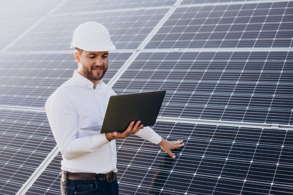 homme à côté de panneaux solaires