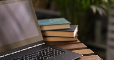 ordinateur près de livres sur une table en bois