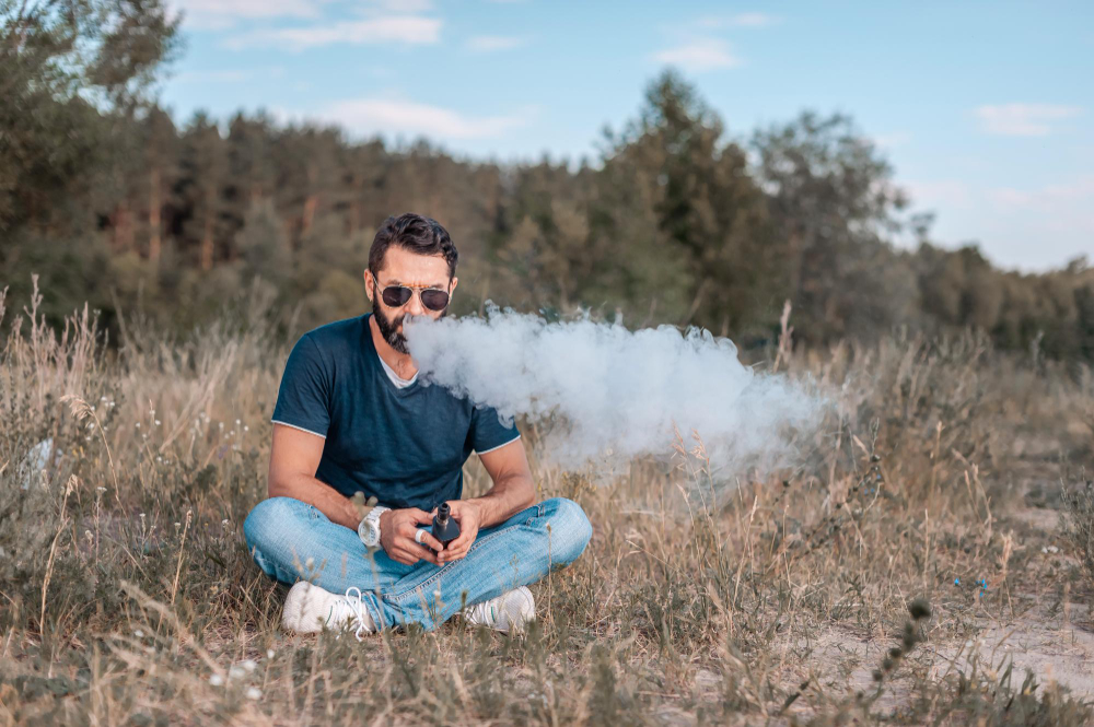 un homme fumant une cigarette electronique